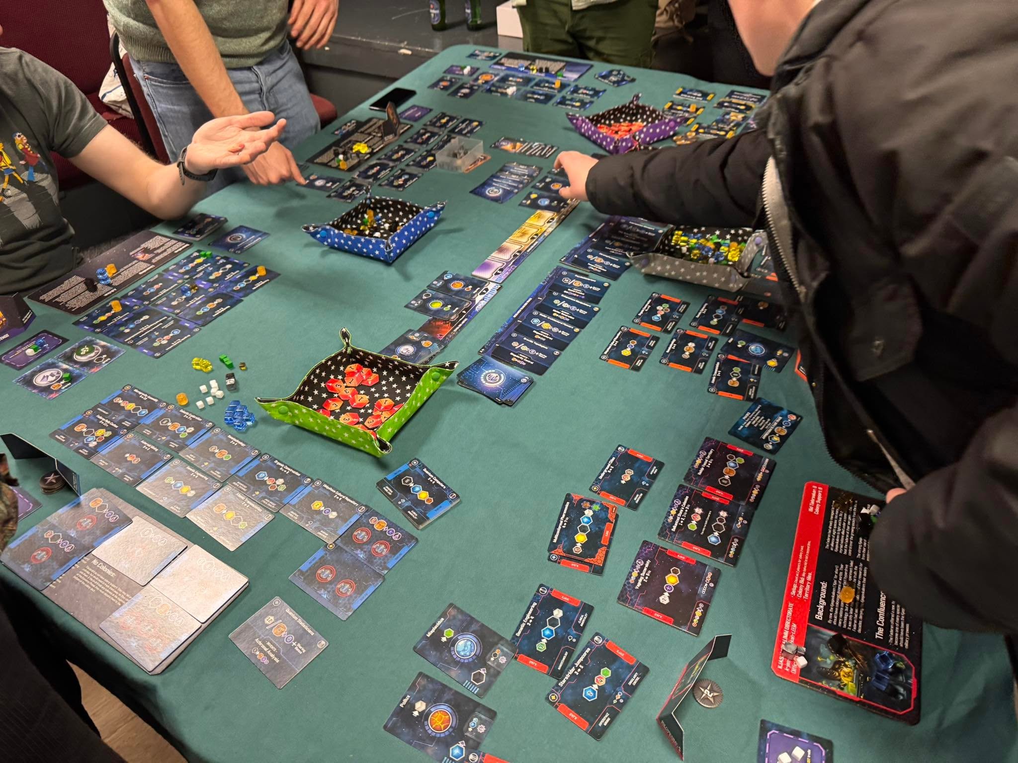 Players around a space-themed card game at SLBG